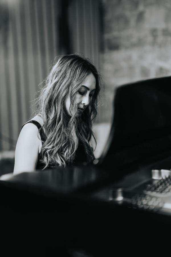 A pianist looking down at the keys, in black and white